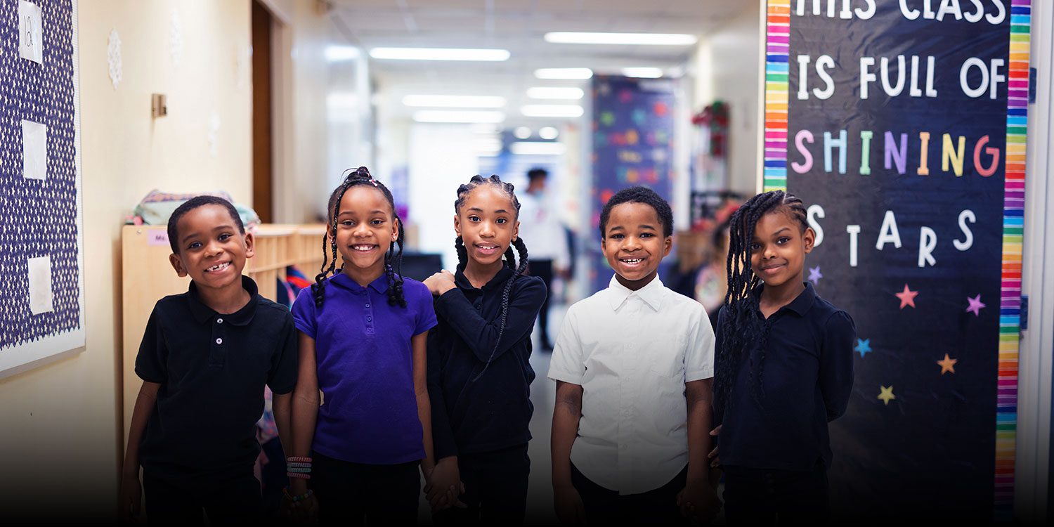 Smiling students standing in the hallway